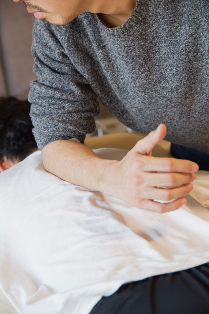 Ein Mann auf einer Liege erhält gerade eine Physiotherapie